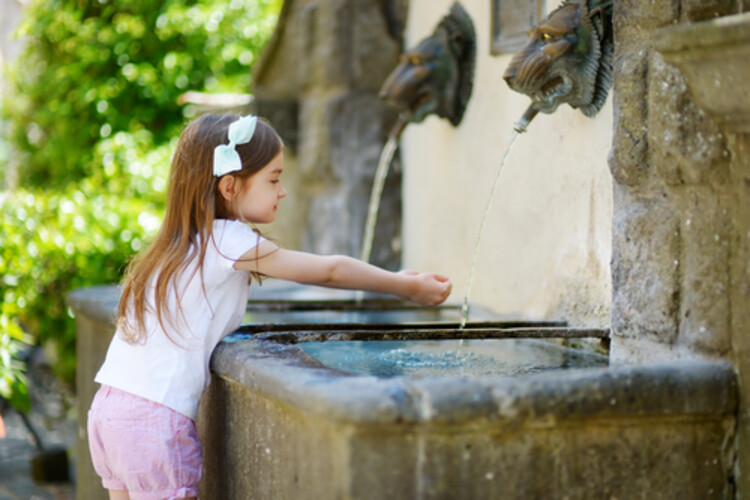 Photo d'une petite fille devant une fontaine à eau Crédit : Epictura